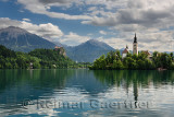 Stol and Begunjscica peaks of Karawanks mountains over Lake Bled with Assumption of Mary church on Island and Bled Castle Sloven