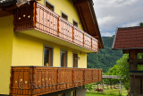 Yellow alpine style house with wood balcony and Cika cattle in back yard field in Gorenjska region Selo village at Bled Slovenia
