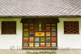 Colorful hand painted apiary beehive covers decorating the side of a building with stone roof at Dornk farm Mlino village Bled S