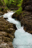 Wood walkway over turquoise water of rapids on Radovna river Vintgar Gorge forest with sedimentary limestone rock layers Sloveni