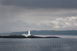 Lismore Lighthouse on Eilean Musdile Islet off Lismore Island with rain and clouds over the west coast highlands Scotland UK