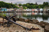 Rusted anchor on jetty and colorful houses reflected in the water of Tobermory harbour on the Isle of Mull Scottish Inner Hebrid