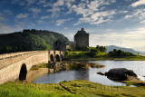 Evening sunlight on new stone arch footbridge to restored Eilean Donan Castle on Island at three lochs in Scottish Highlands Sco