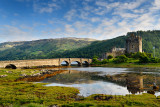 Evening light on restored Eilean Donan Castle with sun on added stone arch footbridge to the Island in Scottish Highlands Scotla