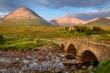 Sligachan Old stone Bridge over River Sligachan with Glamaig and Beinn Dearg Mhor peaks of Red Cuillin mountains at sunset Isle