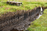 Trench cut into deep Peat of wetland moors on Isle of Skye Scotland to drain water for harvest