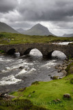 Sligachan Old stone Bridge over River Sligachan with Marsco peak of Red Cuillin mountains after a storm Isle of Skye Scotland UK