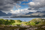 Sun on Ardheslaig village on Loch Beag and fish farm on Loch Shieldaig and Torridon Hills at Upper Loch Torridon Scottish Highla