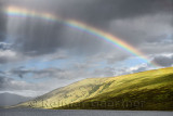 Rainbow and dark clouds over Loch a Chroisg ending at An Liathanach Hill near Badavanich Scottish Highlands Scotland UK