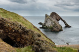 Cave and Bow Fiddle Rock quartzite sea arch with pebble beach at Portknockie on the North Sea Atlantic ocean Scotland UK