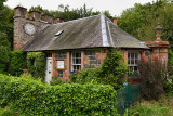 West Clock Lodge coach house in Sheriffmoor Plantation Forest at Eagle Lodge Scottish Borders Scotland UK with ivy and clock on
