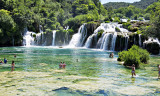 de rivier de Krka  stroomt via de waterval in een stil meer waarin liefhebbers kunnen zwemmen