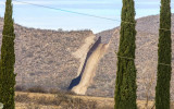 Gouged out hill frames the border wall in the Arizona Border Zone