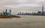 New Jersey and Ellis Island (left) and NYC Skylines under cloudy skies from Liberty Island