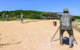 Sculpture of first flight scene, from behind the photographer, in Wright Brothers National Memorial