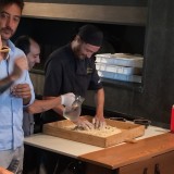 Showing how they make the pizzia dough