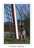 Swinging the folded sail free from the hooks that hold them when in rest.
