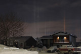 Multicoloured pillars from low level ice crystals reflecting artificial lights.