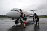 Boarding Air Niugini Fokker 100 (P2-ANE) in the rain at Kokopo