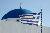 Greek flag with the blue dome of Panagia Malteza Church, Imerovigli