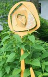Yellow sculpture of a flower, by Tom Cowgill.