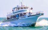 Large fishing boat passes by the Ocracoke Island ferry in North Carolina