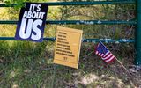 Signs and a flag on the side of US 80 along the Selma to Montgomery NHT