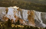 The setting sun through the steam atop Mammoth Hot Springs in Yellowstone NP