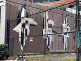 Mural behind a wire fence