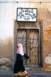 Zanzibari woman passing a doorway in Stone Town