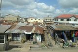 Squatter camp developed on vacant land between the roadway and an existing neighborhood.JPG