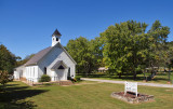 A view of the church showing the sign and cemetary entrance
