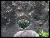 Rick peering through a huge piece of stone money, largest weighs 1/2 ton