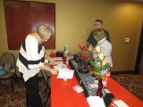 Registration desk.  Linda Proffitt Decker is locating name tags for Ronnie and Vicki Bradshaw.