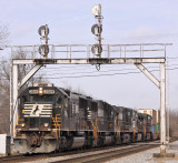 A standard cab SD70 leads NS 295 under the signals at Juntion City