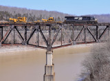A lone EMD brings a CAT High/Wide train over the Cumberland River bridge at Burnside.
