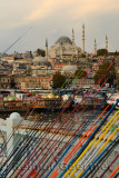 Fishing rods for sale on Galata Bridge over Golden Horn with Suleymaniye Mosque Istanbul