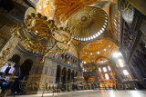 Morning light in an empty Hagia Sophia with chandeliers and golden dome