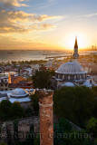 Setting sun behind the Sokollu Mehmet Pasha mosque minaret and historic Dervish ruins on the Marmara Sea Istanbul