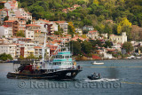 Fishermen seine fishing on the Bosphorus Strait with houses on hill at Yeni Mahalle Sariyer Turkey