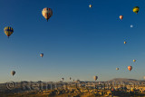 Morning sun and hot air balloons over Goreme and Uchisar villages in Cappadocia Turkey with National Park and Love Valley