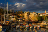 Tall ships and boats in at Antalya harbour Turkey with Roman wall fortificaiton at sundown