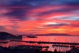 Red sky sunset at Kusadasi Turkey Harbour with Cruise ship and Guvercin Adasi castle on the Aegean Sea with mountains of Samos I