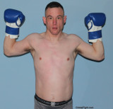 younger boxing stud flexing his arms.jpg