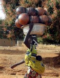 Heavy clay pots and the baby are carried many kilometres to the next market, Burkina Faso