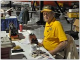 Ed Lusk sits at control table for G scale layout