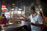 MALACCA, MALAYSIA - FEBRUARY: Devotees pray by placing joss-sticks in bronze jars placed on the altar on the first day of the Ch