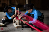 GUANGXI, CHINA - MAY 21: Womenfolk from the Yao ethnic minority weave garments the traditional method at their homes on May 21, 