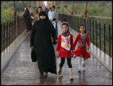 Walking grandmother over suspension bridge at Deir ez-Zor
