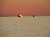 Boat in front of the sunset off Naples Beach Florida